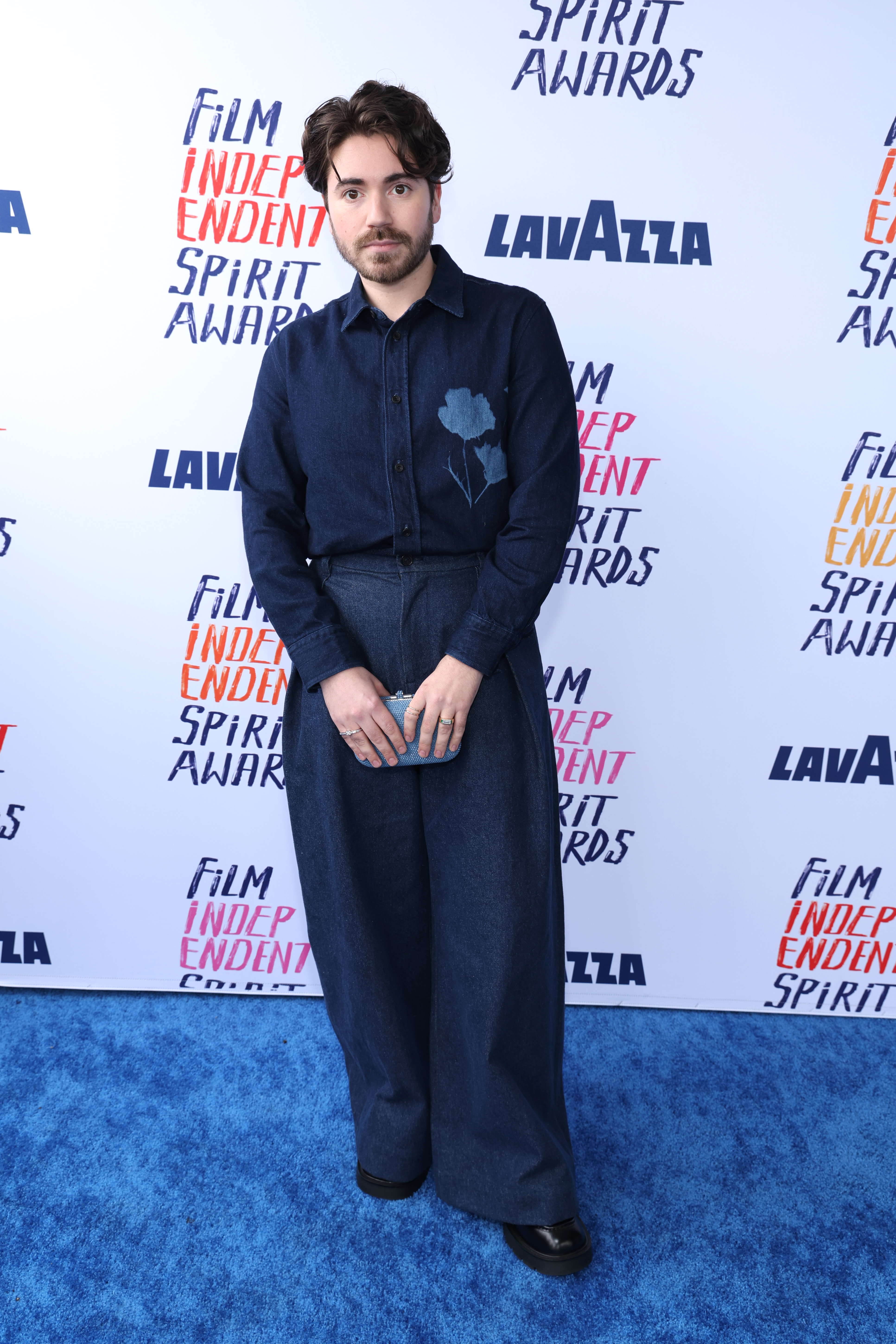 Noah in denim suit with flower detail posing at Film Independent Spirit Awards