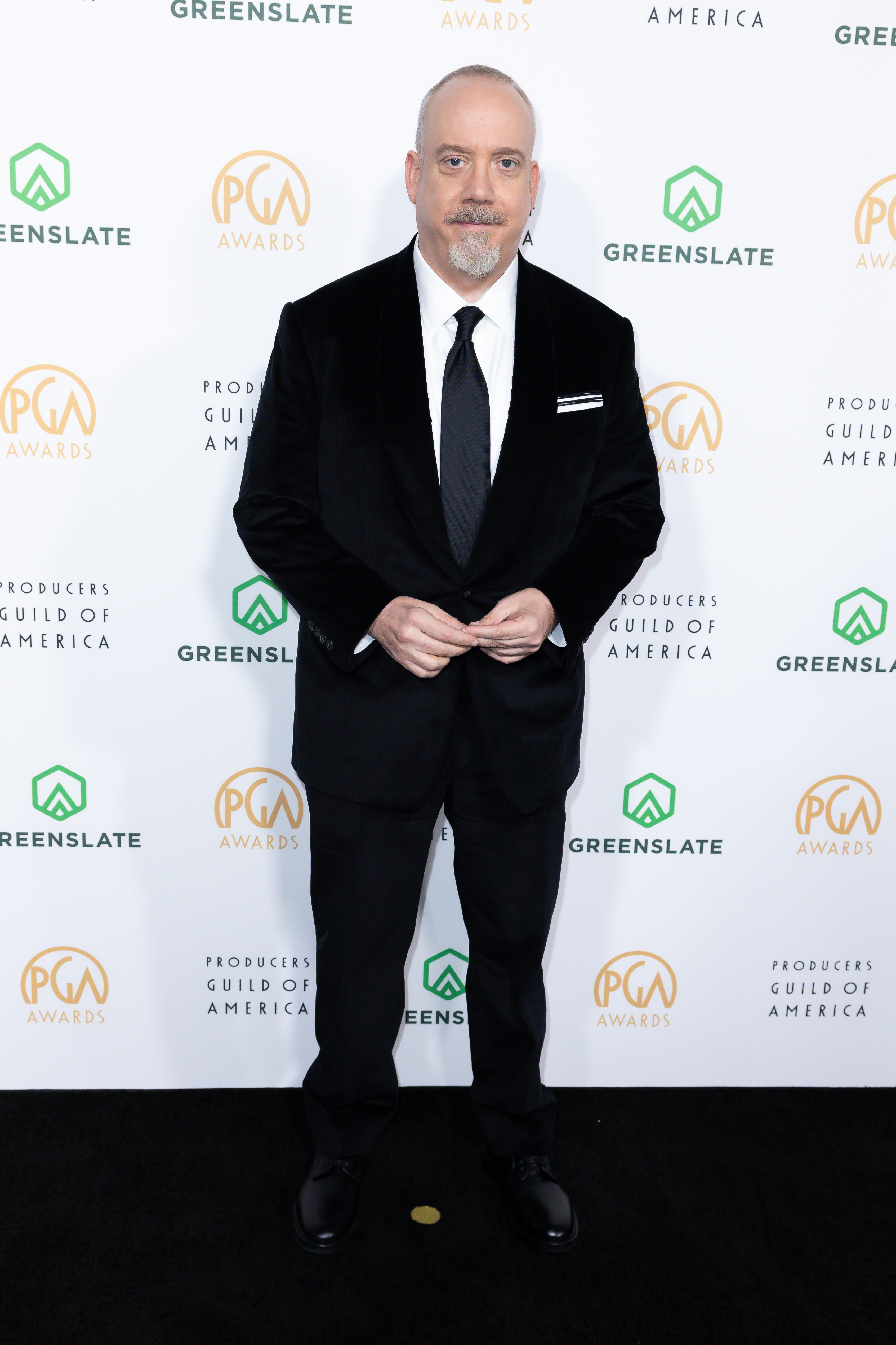 Paul in a suit standing in front of a step-and-repeat banner at the PGA Awards