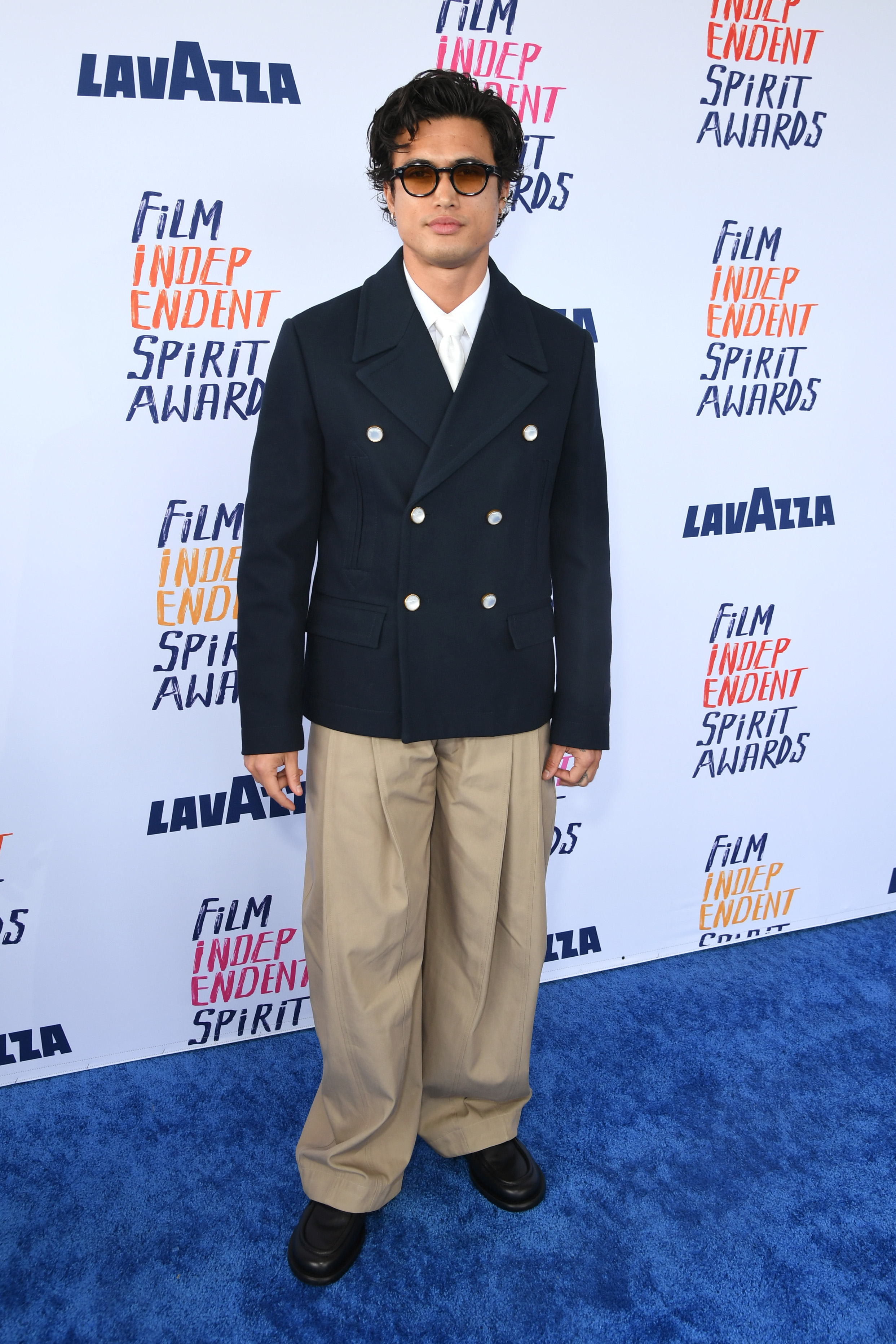 Charles in a double-breasted jacket and wide-leg trousers poses at the Film Independent Spirit Awards