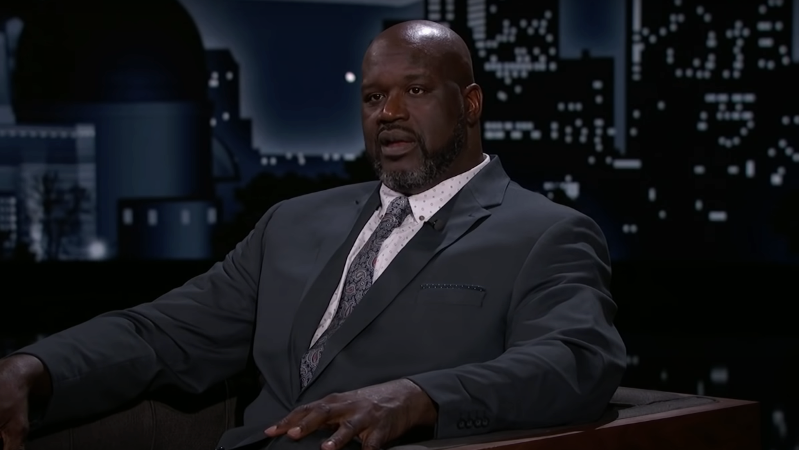 Shaquille O&#x27;Neal in a talk show setting, wearing a suit and patterned tie