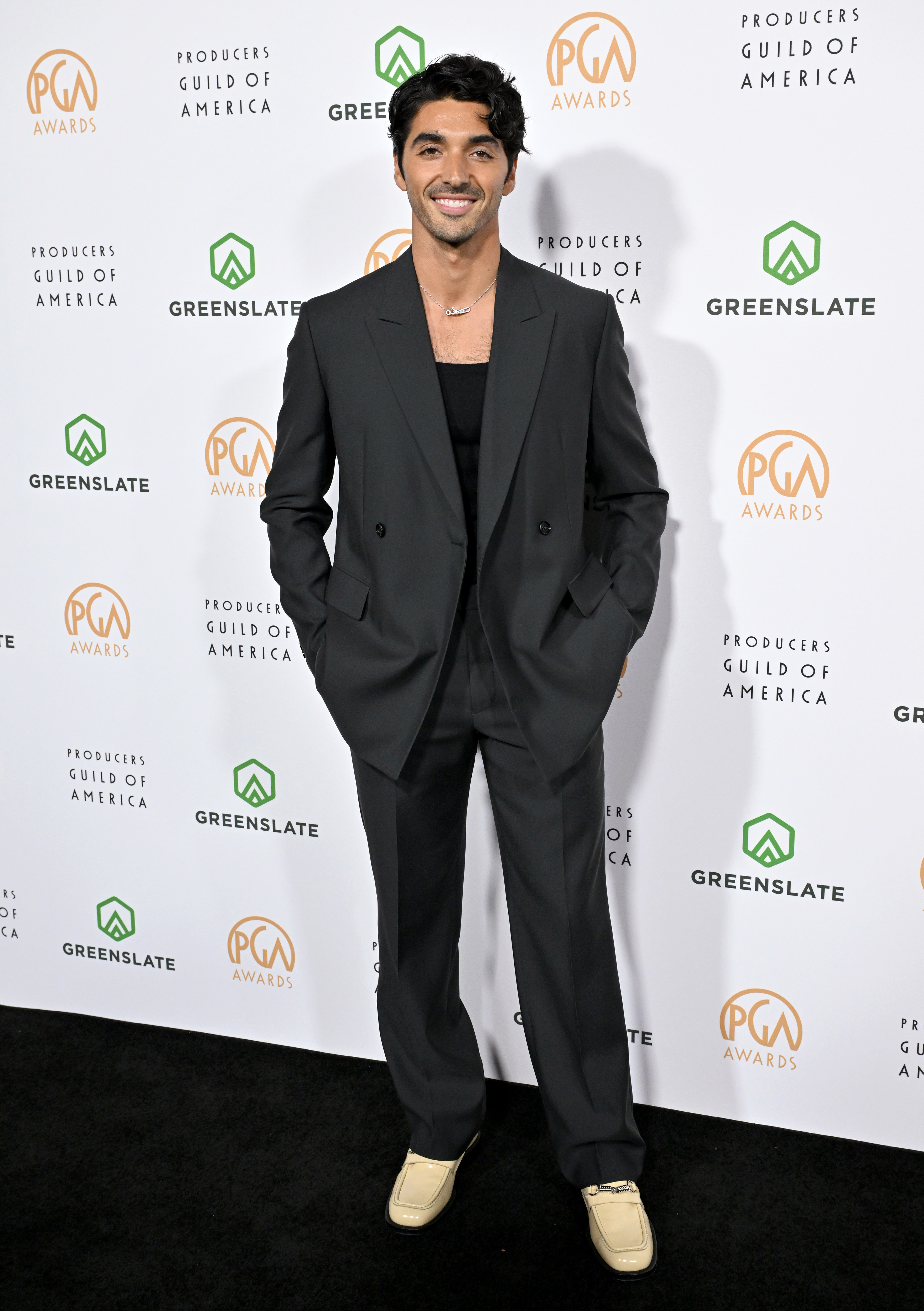 Taylor in a oversized suit with sneakers poses at the Producers Guild Awards