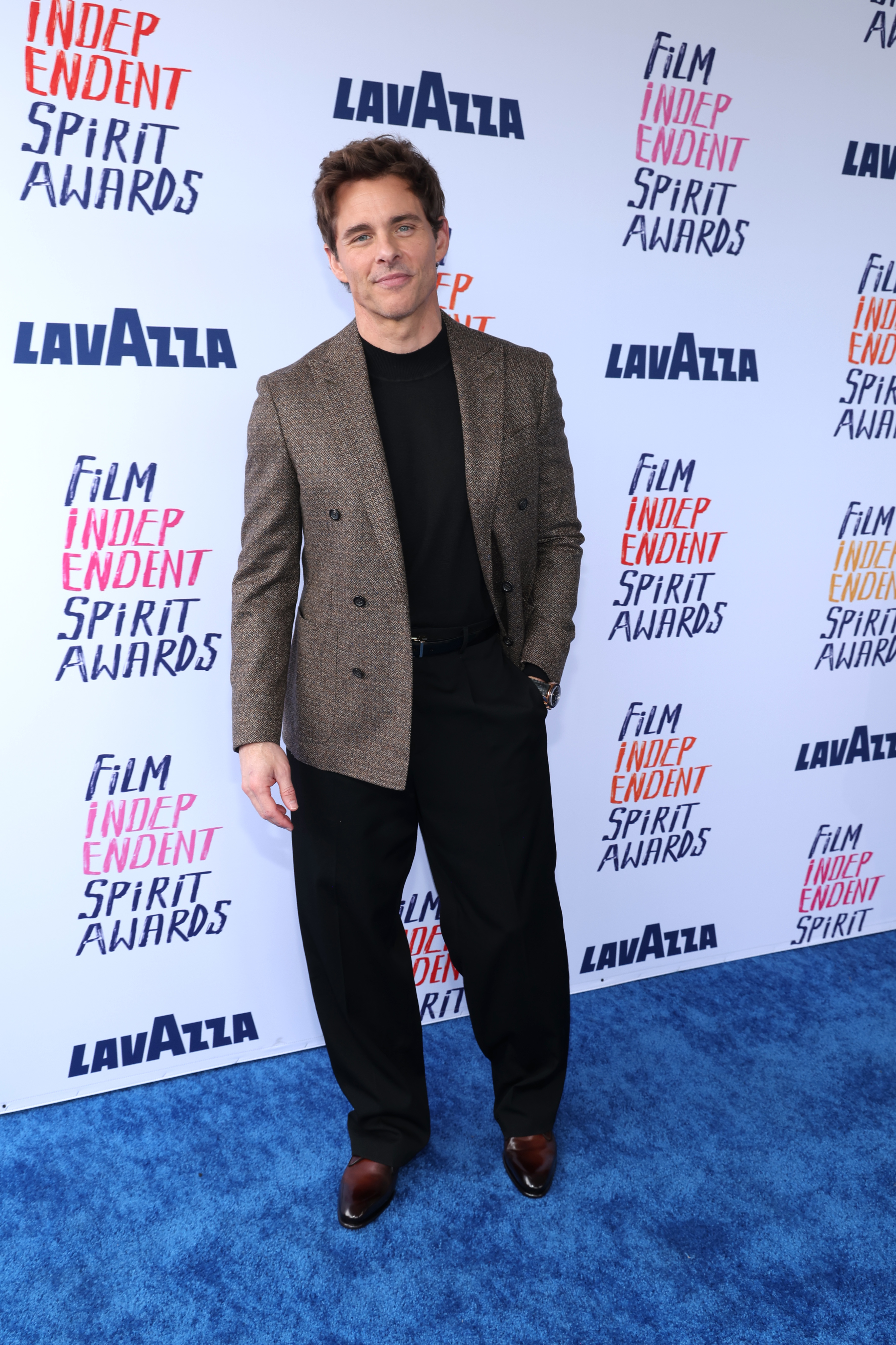 James wearing a blazer over a top with dress shoes