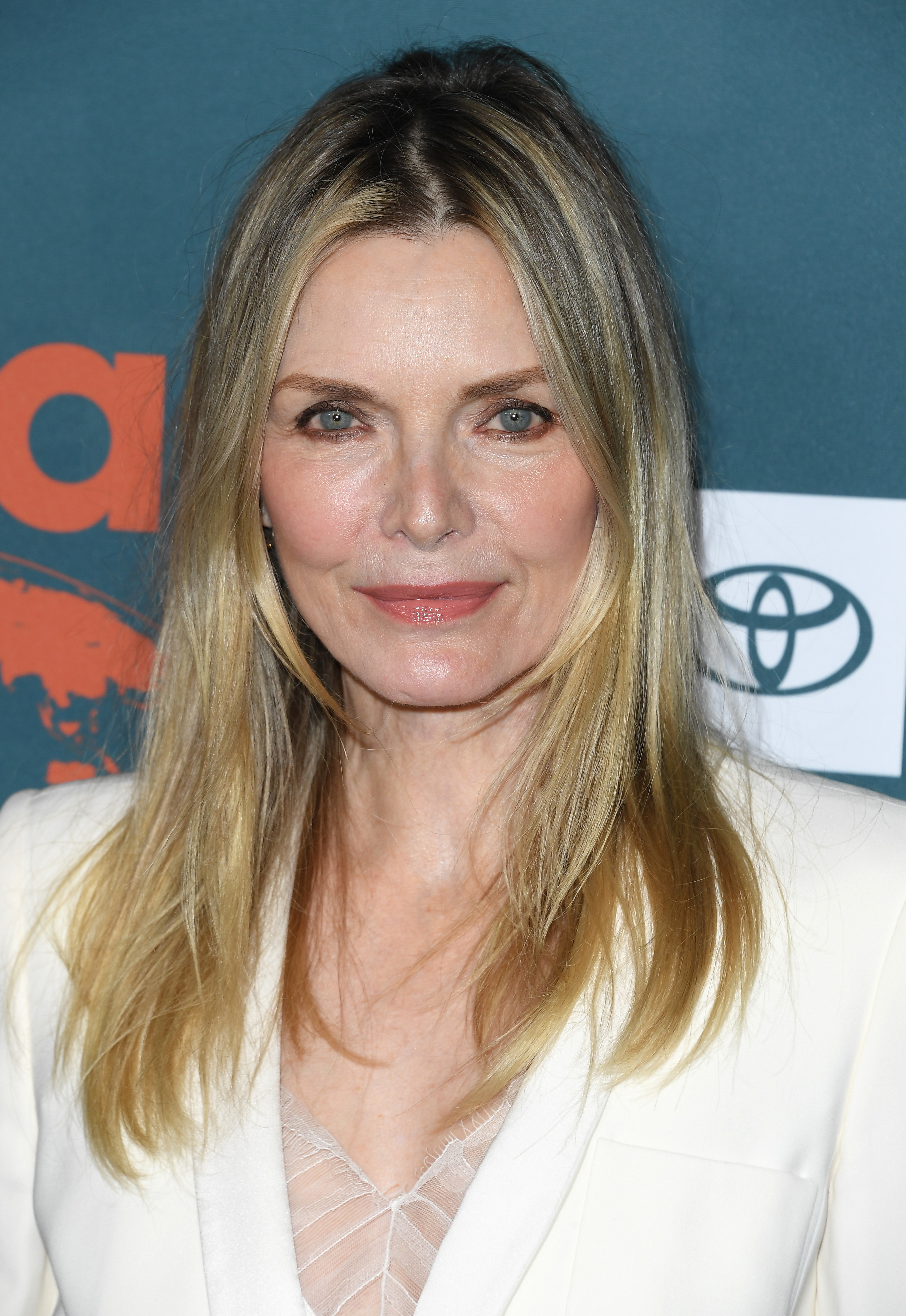 Michelle Pfeiffer in a blazer over a lace-detailed top at an event