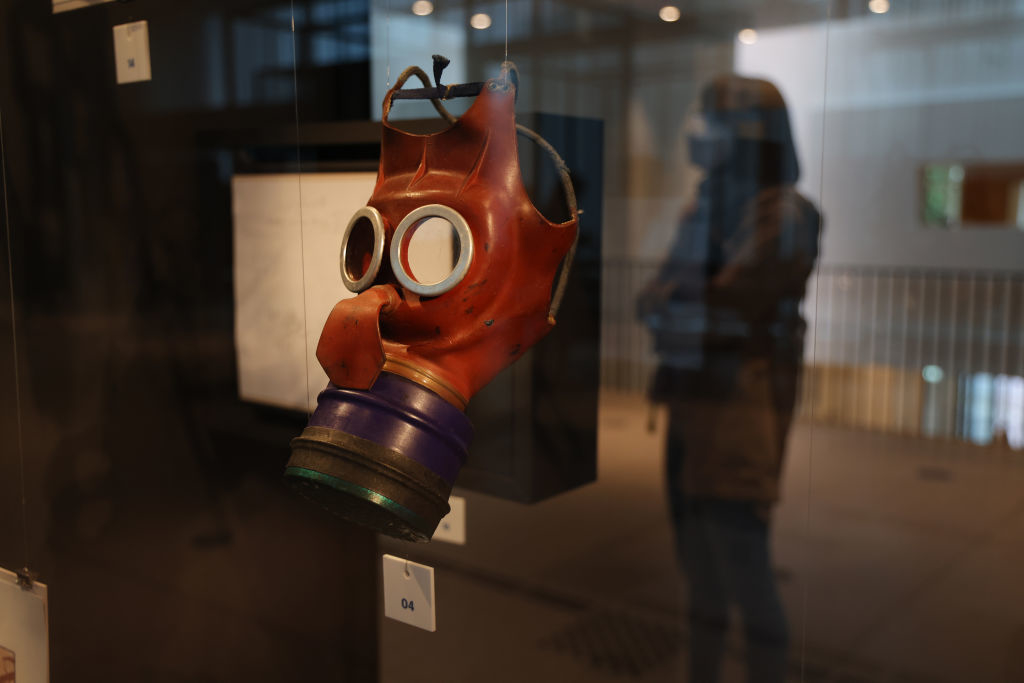 A child&#x27;s gas mask with a balloon-like nose displayed in a case
