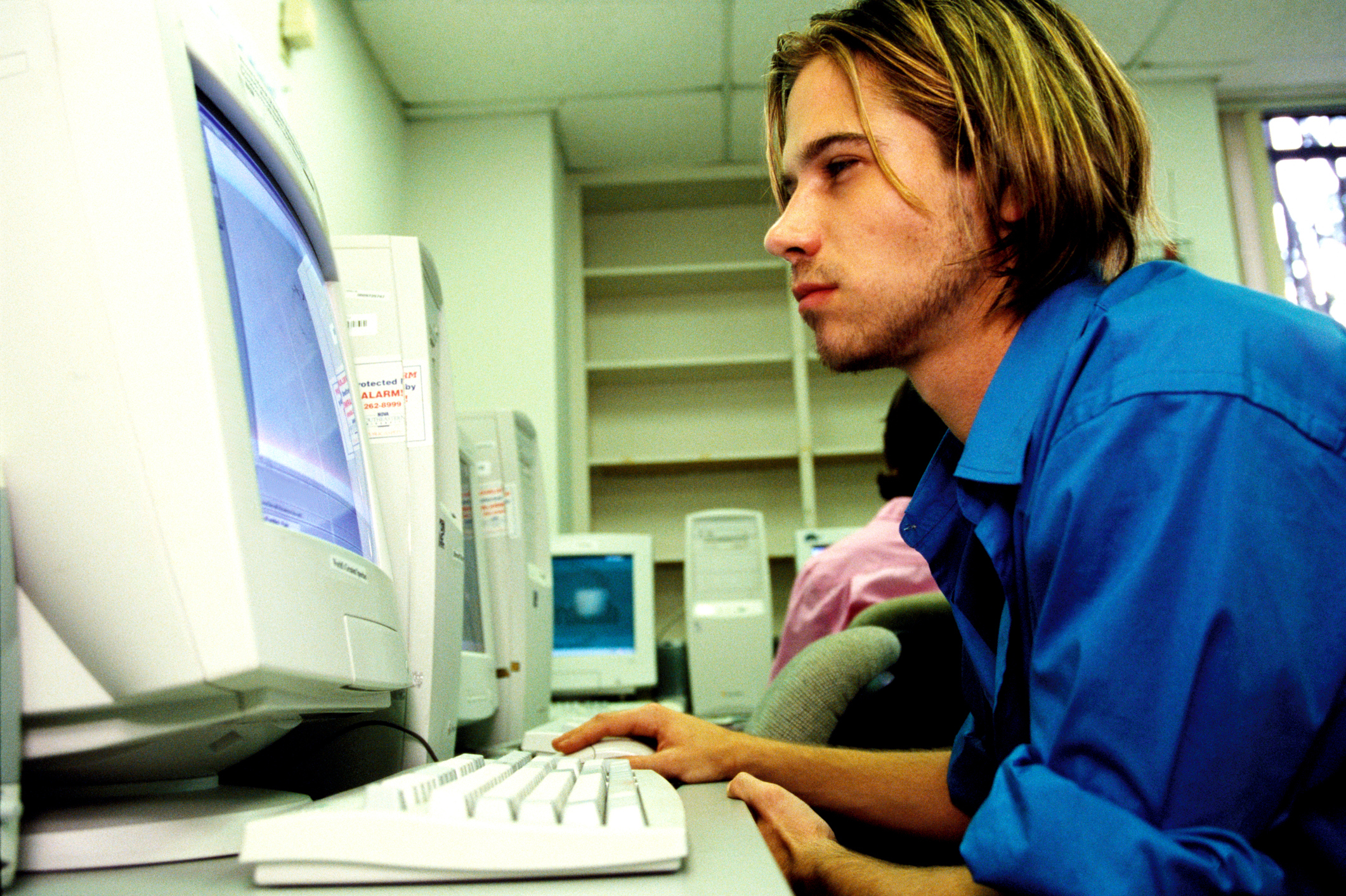 Person focused on computer screen in a work environment