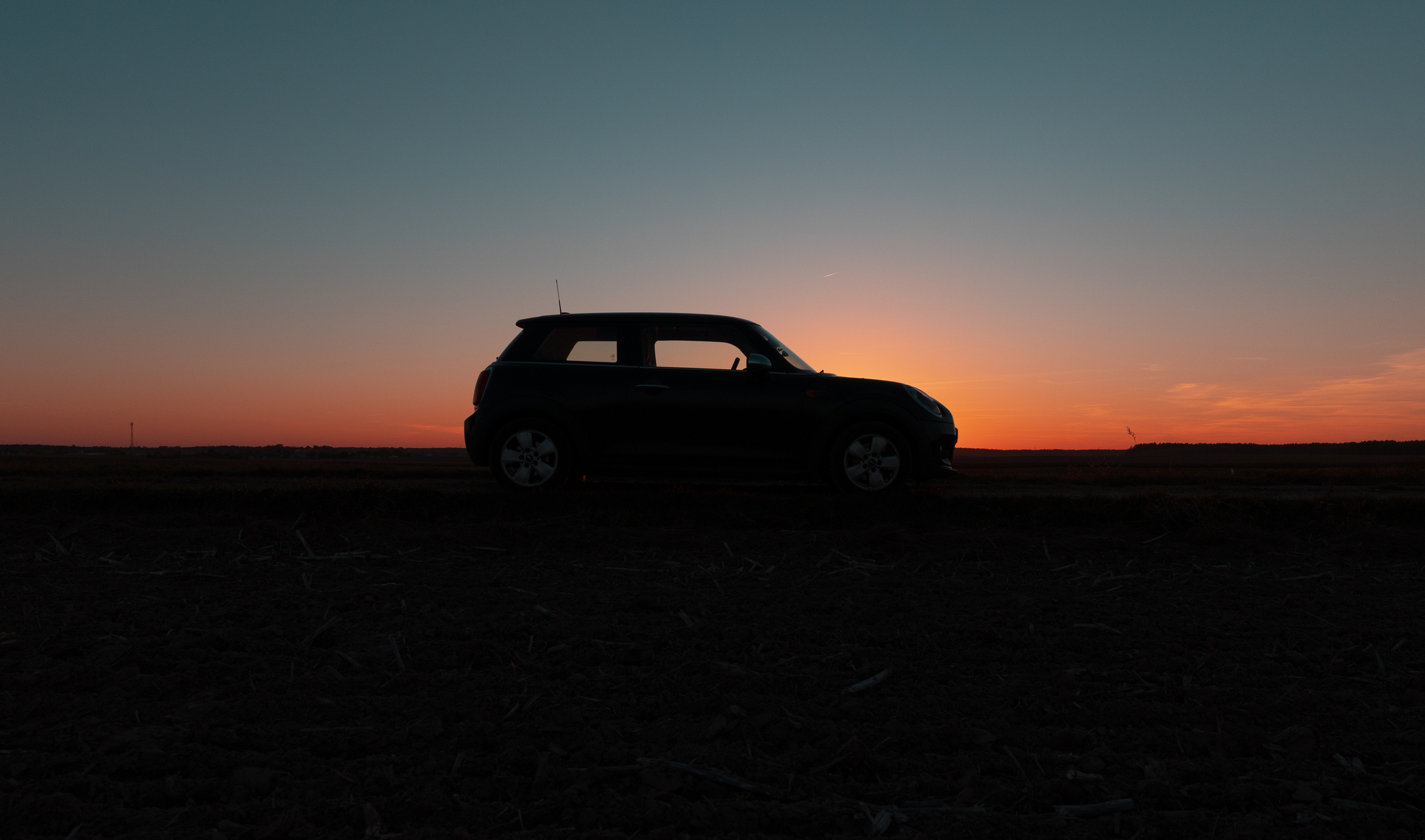 Silhouette of a car against a sunset sky