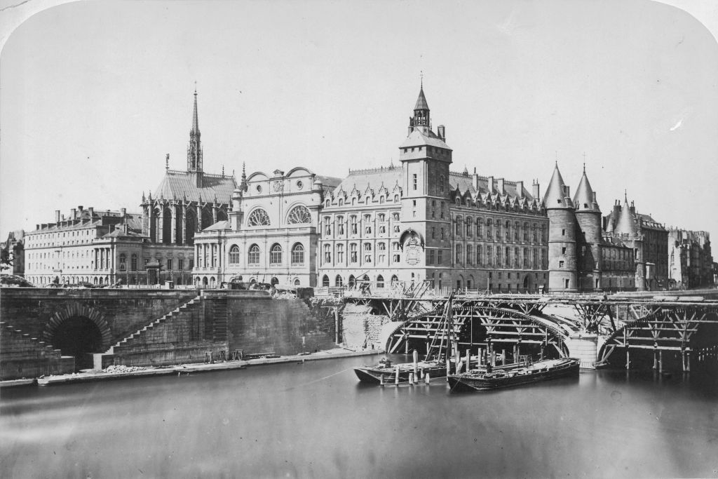Historical architecture by a river with bridge under construction foreground