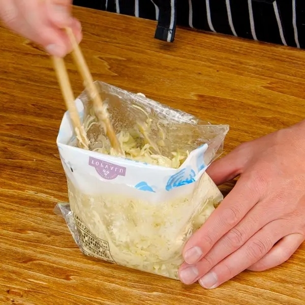 ポリ袋に入れた材料を箸でかき混ぜている。