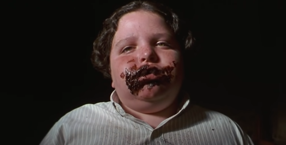 A boy with chocolate cake smeared all over his face