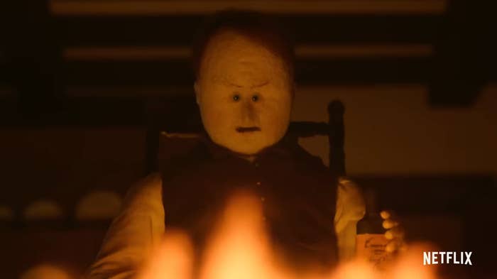 Candlelit scene with a concerned-looking character in a dark room from Netflix series