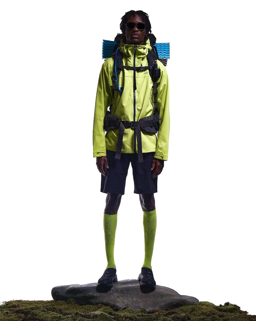 Person in hiking gear with backpack standing on a rock