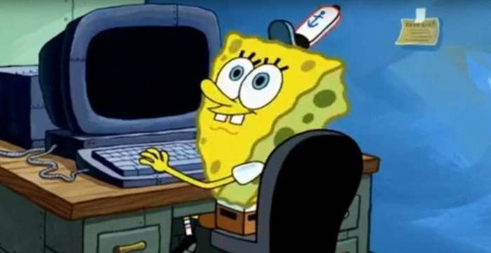 SpongeBob SquarePants character smiling at a computer desk inside