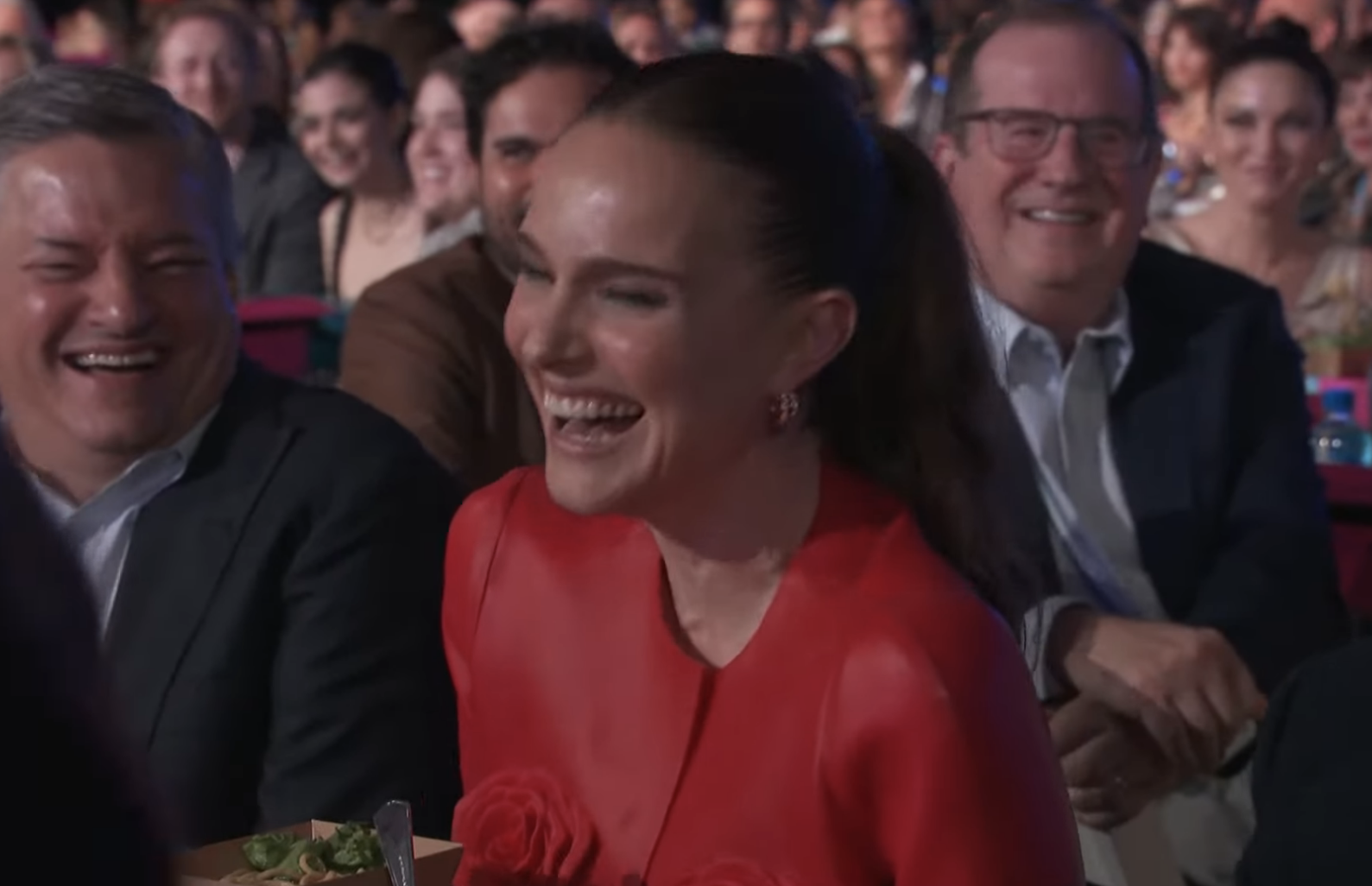 Natalie laughing with a joyful crowd around her