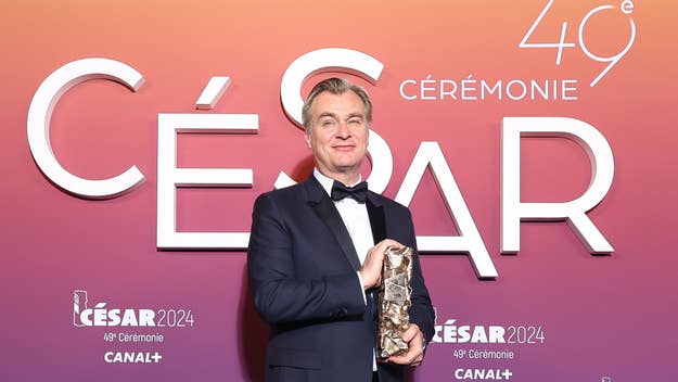 Christopher Nolan holding a César award, in formal attire, at the 49th César Ceremony
