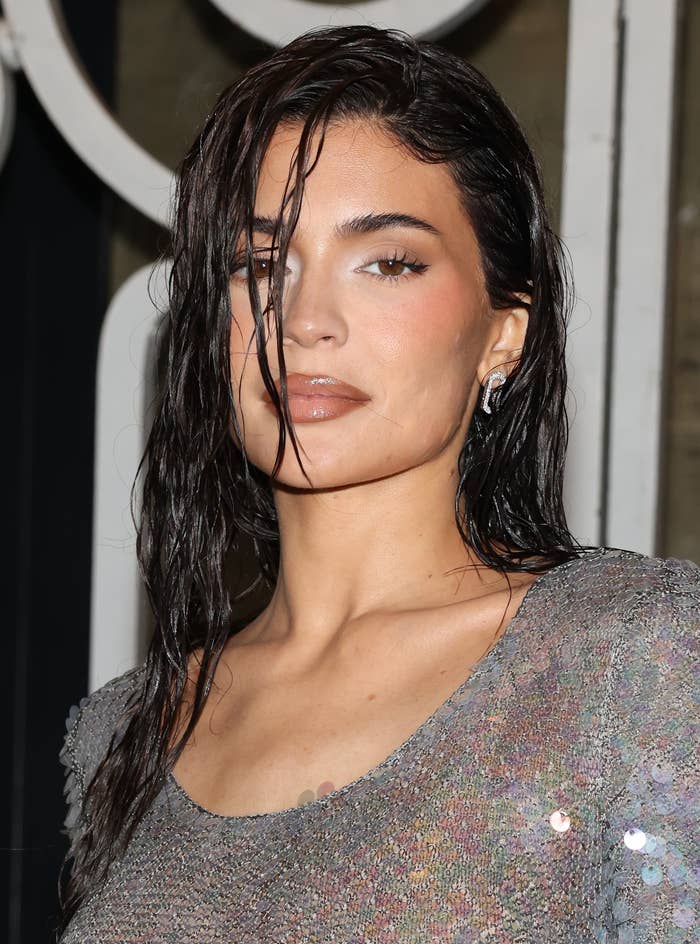 Close-up of Kylie Jenner with wet hair, wearing a sequined outfit with a scoop neck