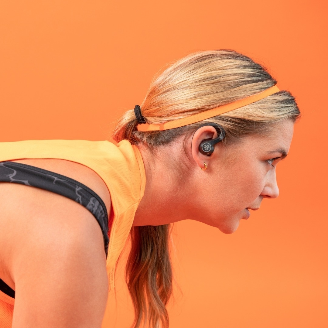 A model wearing the wireless earbuds, focused on their workout