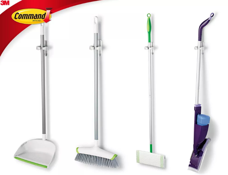 A dust pan, broom, Swiffer, and small vacuum held up and organized with the Command grippers