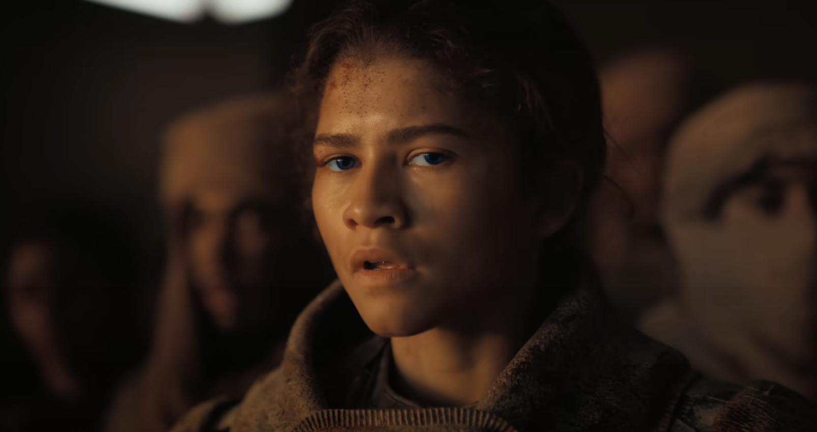 Close-up of an emotional Zendaya as Chani in &quot;Dune,&quot; surrounded by others