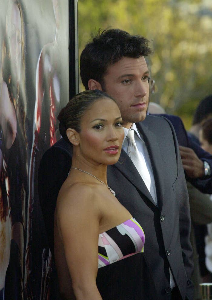 Jennifer Lopez wearing a sleeveless dress with a diagonal stripe design and Ben Affleck in a classic suit at a premiere