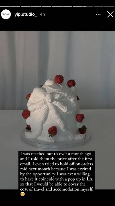 White cake decorated with cream swirls and raspberries on a stand, with a text overlay from a social media post
