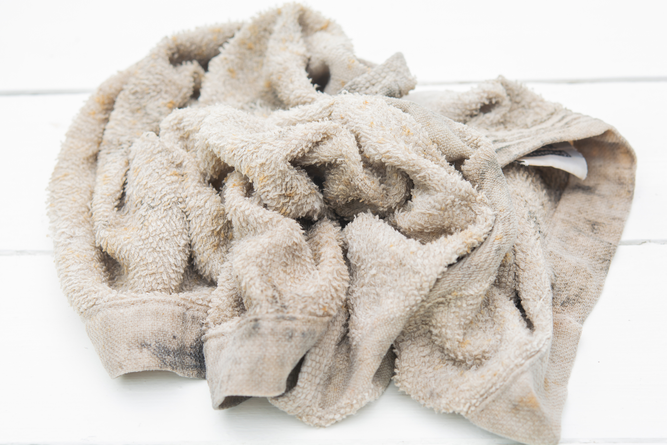 A crumpled, dirty towel on a white wooden surface