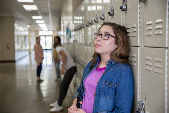 Teenage girl leaning against lockers