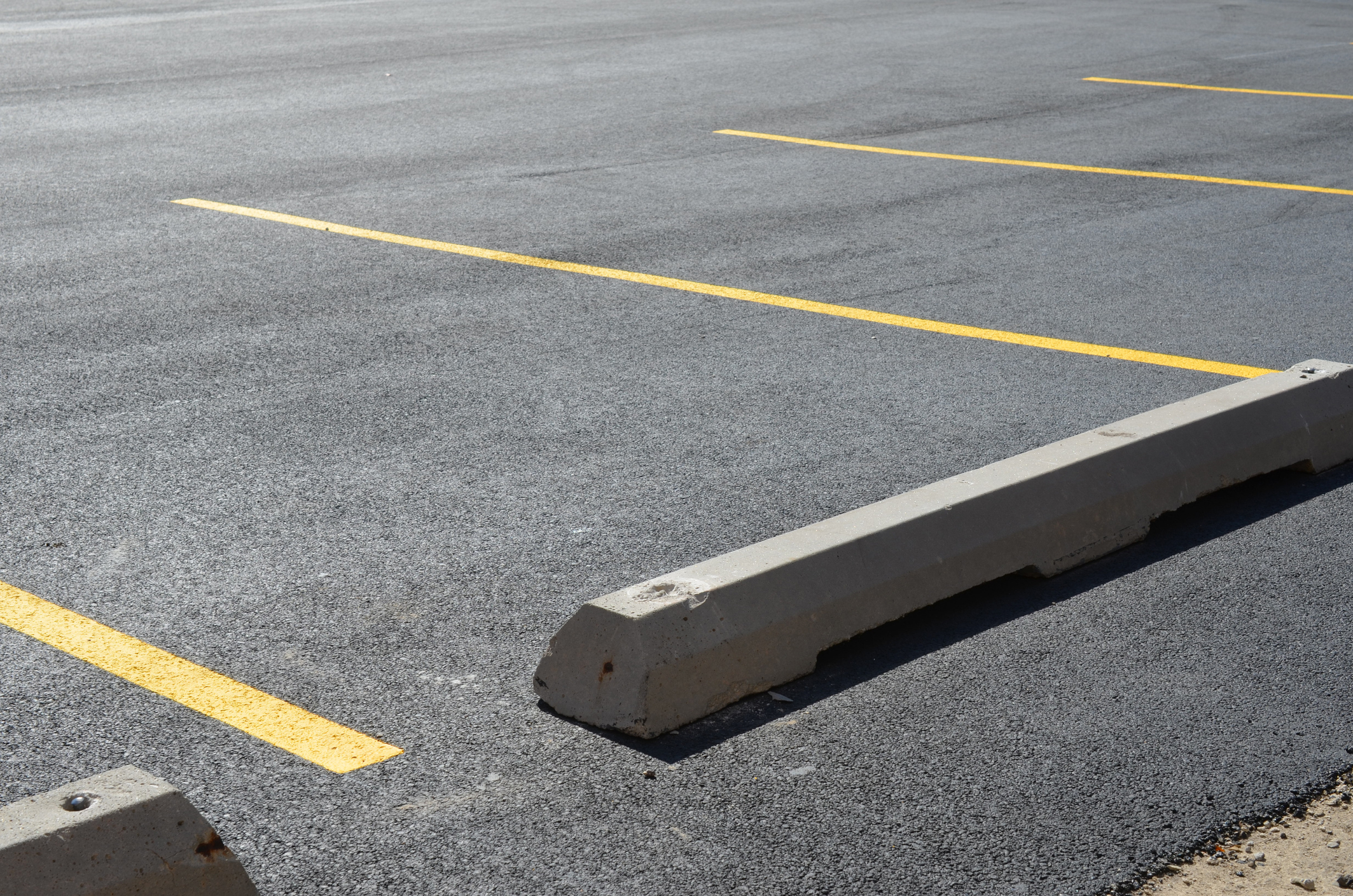 Empty parking space with concrete wheel stops