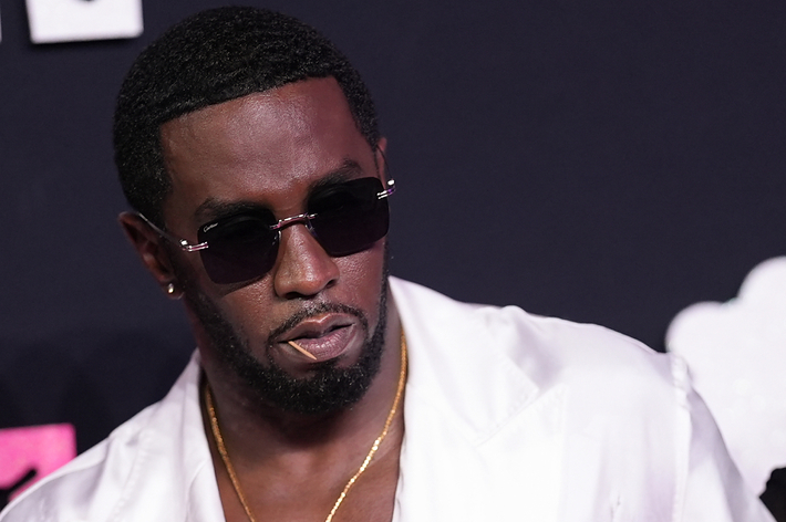 Sean "Diddy" Combs in a white outfit with sunglasses at a music event