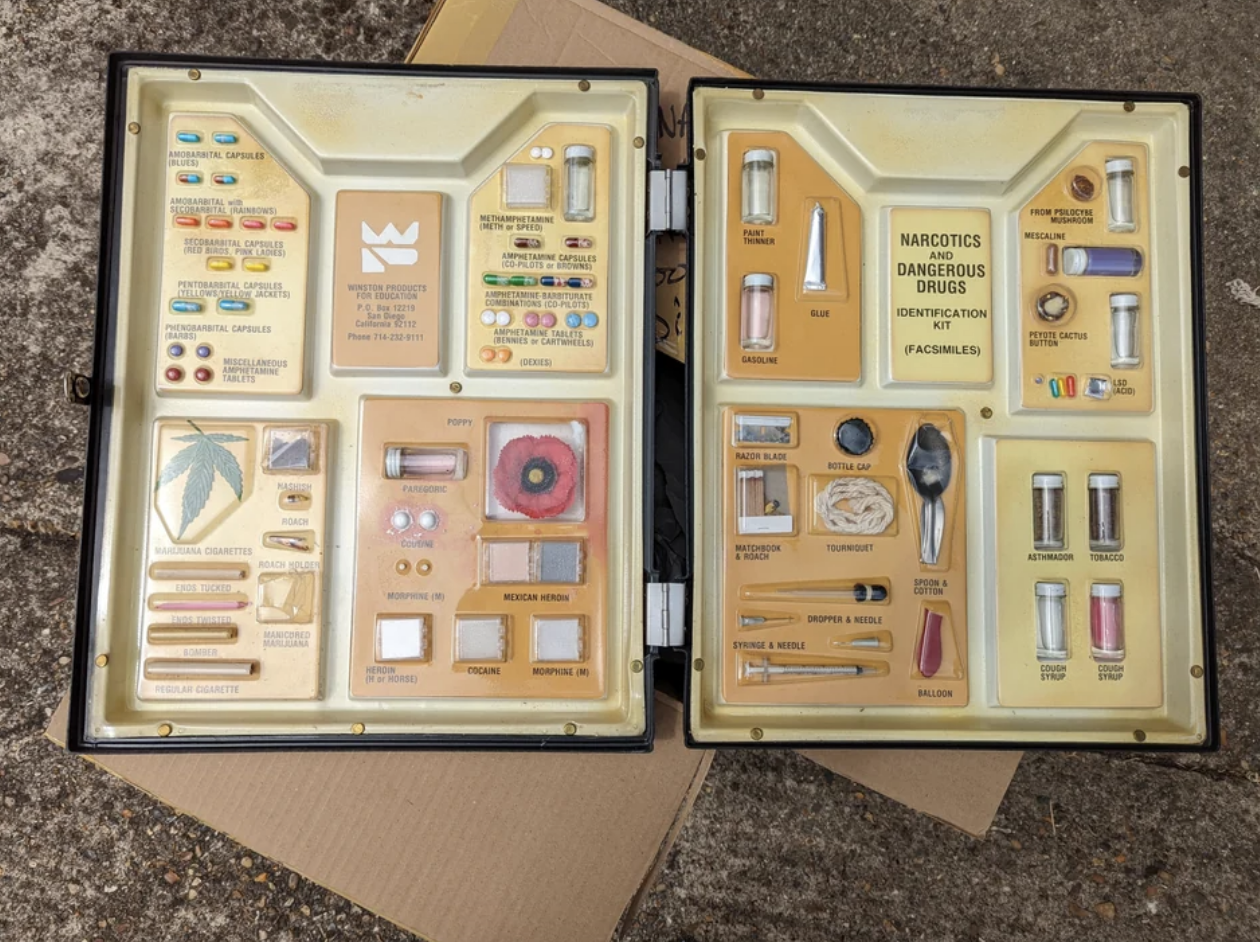 Drug education briefcase displaying various substances and paraphernalia for instructional use