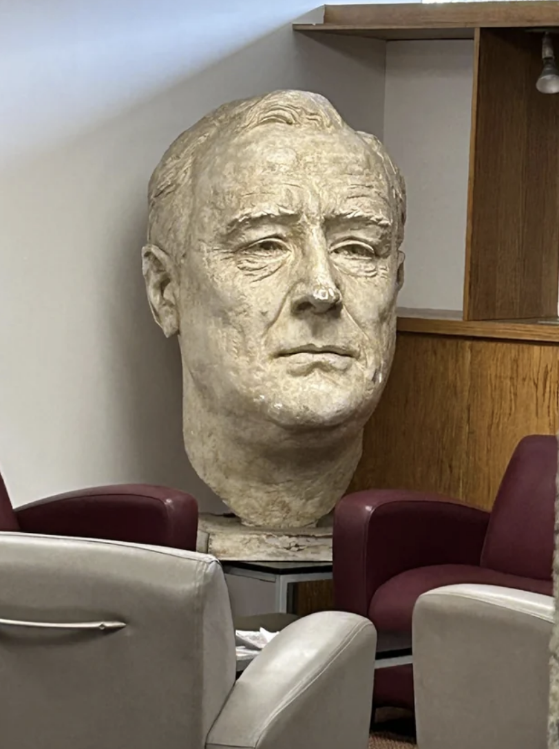 A large sculpture of Franklin D. Roosevelt&#x27;s head displayed in an indoor setting