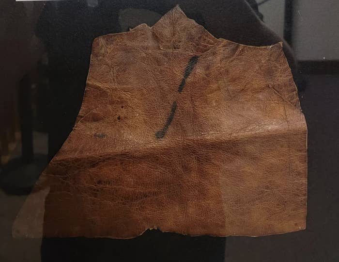 Piece of aged leather with visible creases and a tear