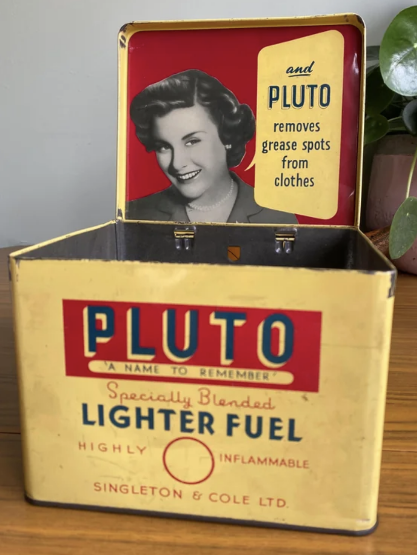 Vintage Pluto lighter fuel tin featuring a smiling woman&#x27;s portrait and branding text that advertises it for use against stains
