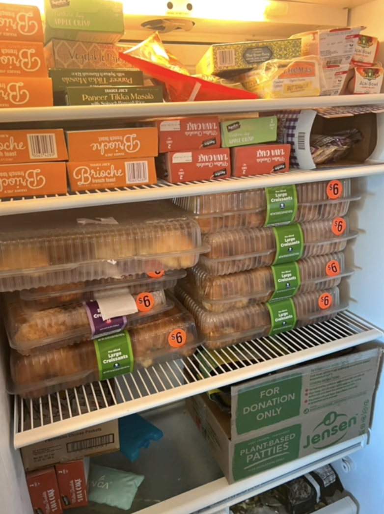 A fridge stocked with multiple packs of prepared sandwiches and meal boxes, some marked with discount stickers