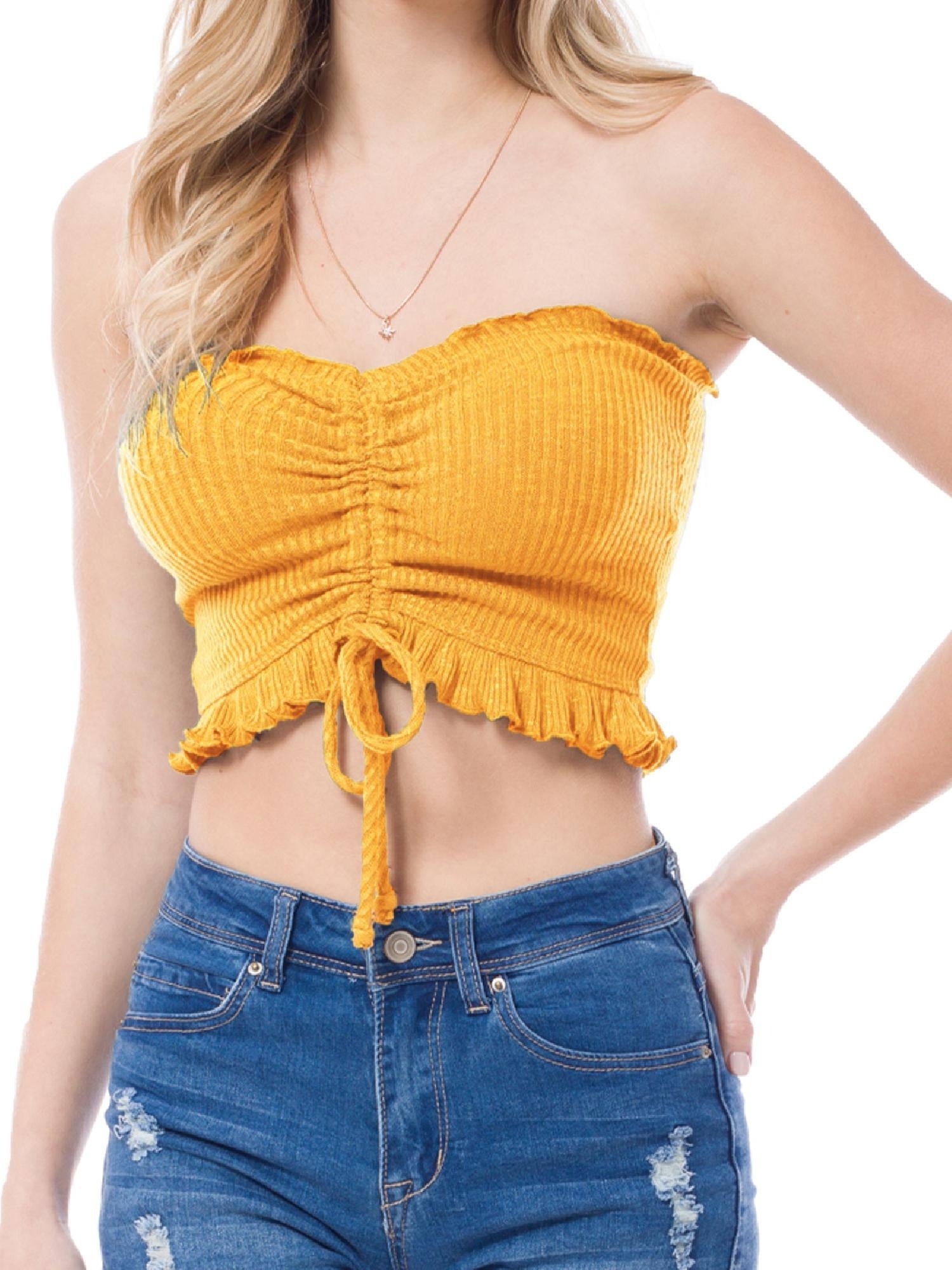 model wearing a yellow cropped top and blue denim jeans