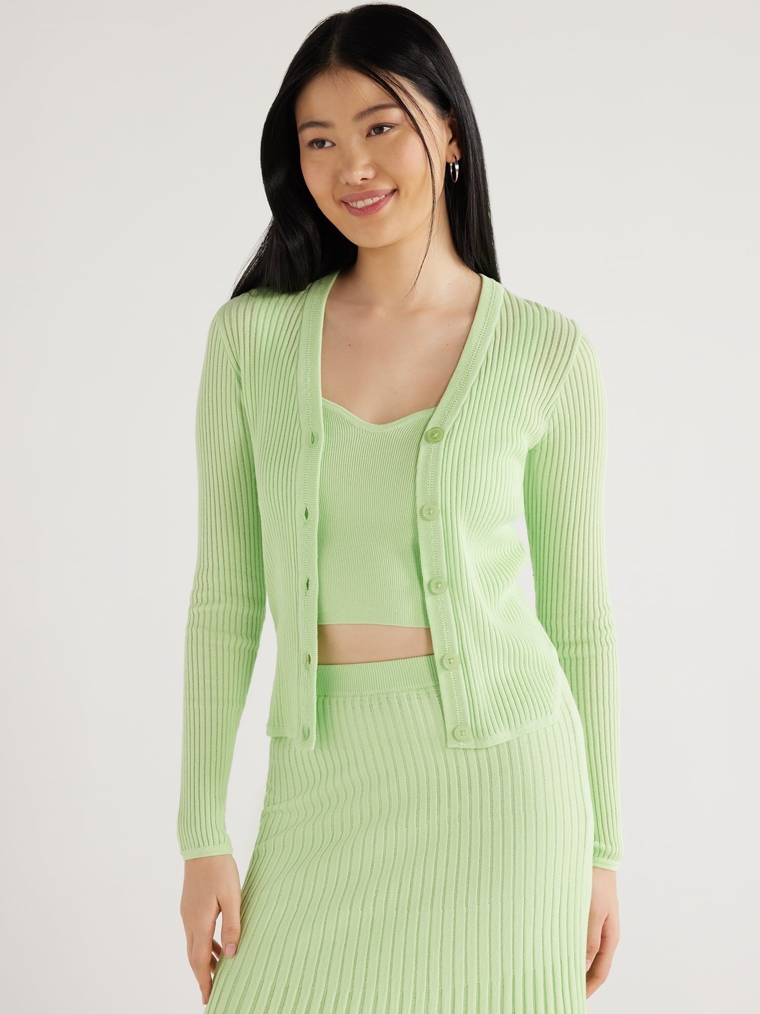 model in a matching ribbed green cardigan, bralette and skirt set