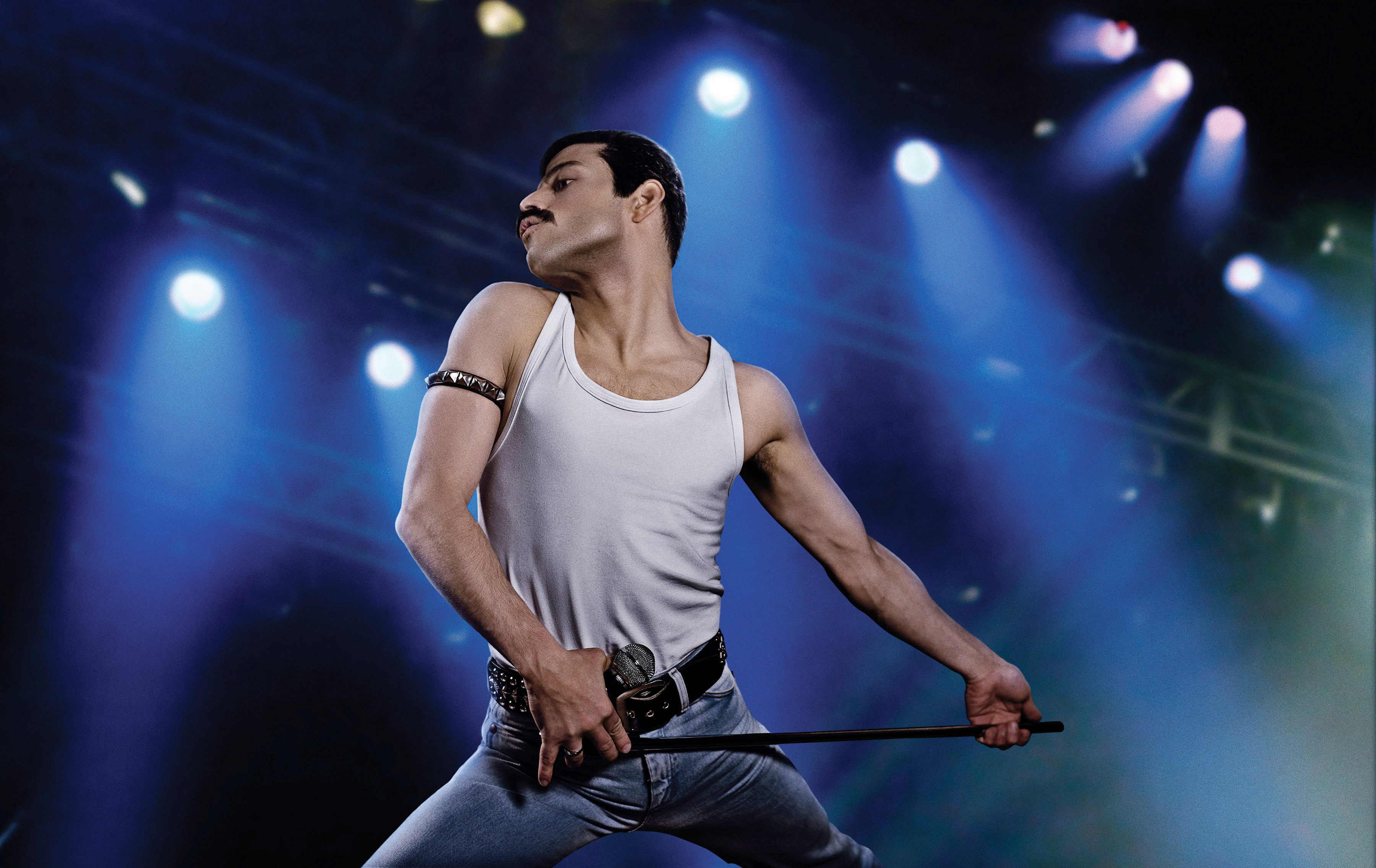 Rami Malek portrays Freddie Mercury on stage with a microphone stand in &quot;Bohemian Rhapsody.&quot;
