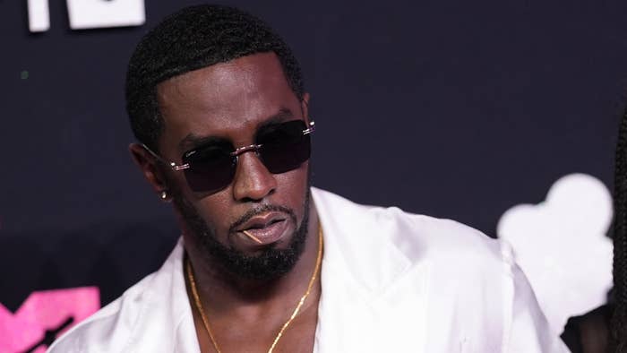 Sean &quot;Diddy&quot; Combs in a white outfit with sunglasses at a music event