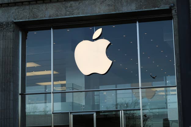 Apple logo on a store facade with interior lights visible