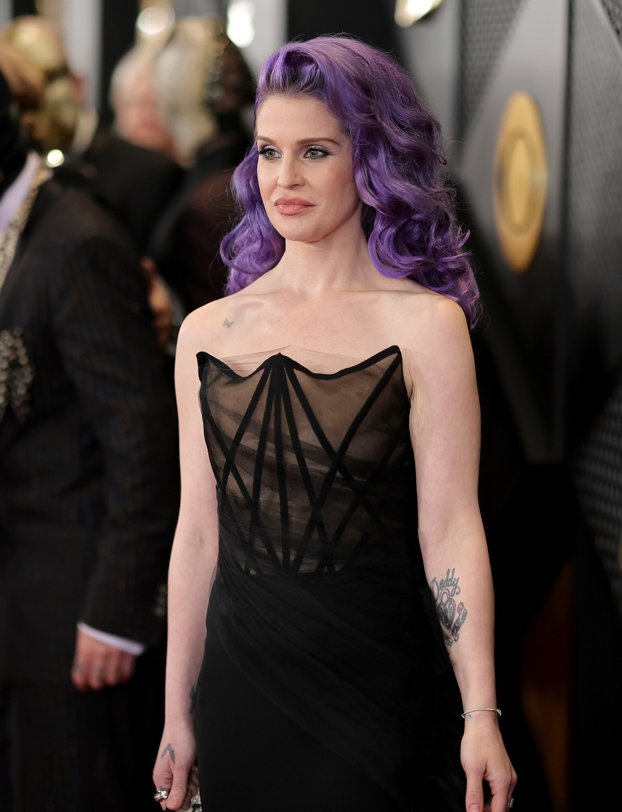 Woman with purple hair in a black dress on the red carpet