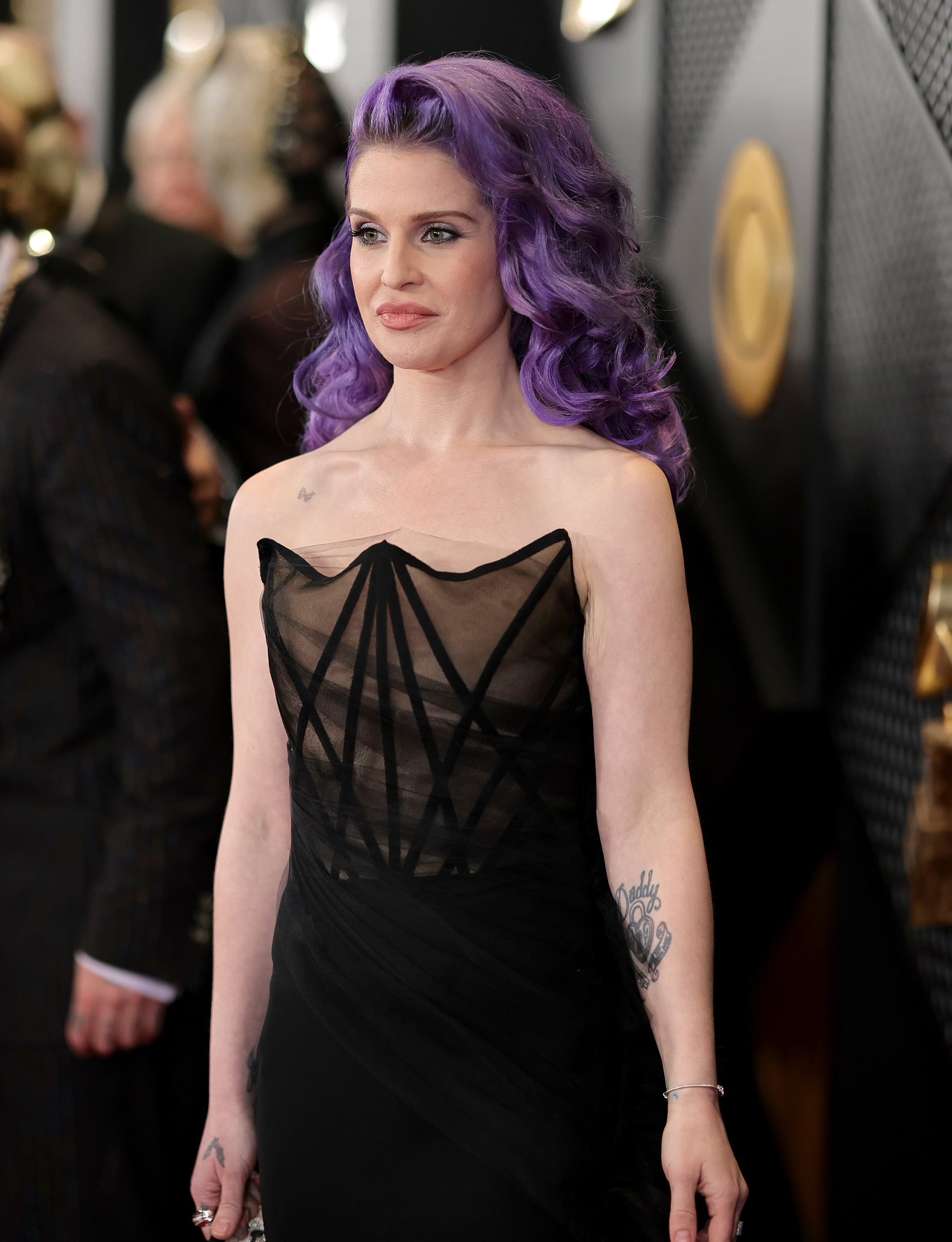 Woman with purple hair in a black dress on the red carpet