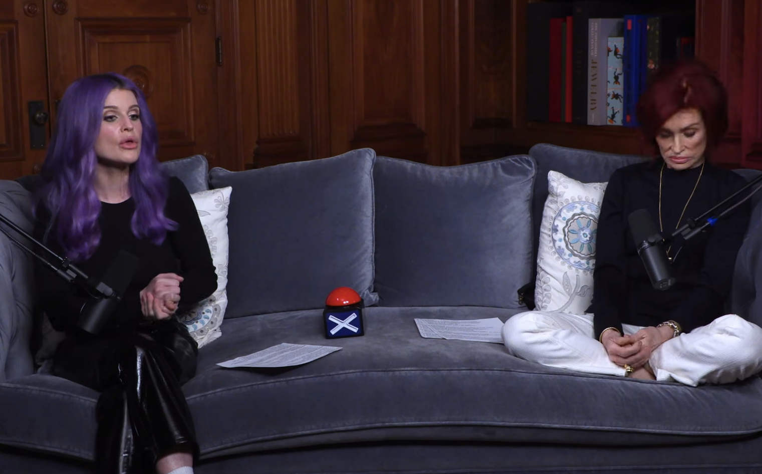 Kelly Osbourne and Ozzy Osbourne sit on a couch during an interview, demeanor relaxed and attentive