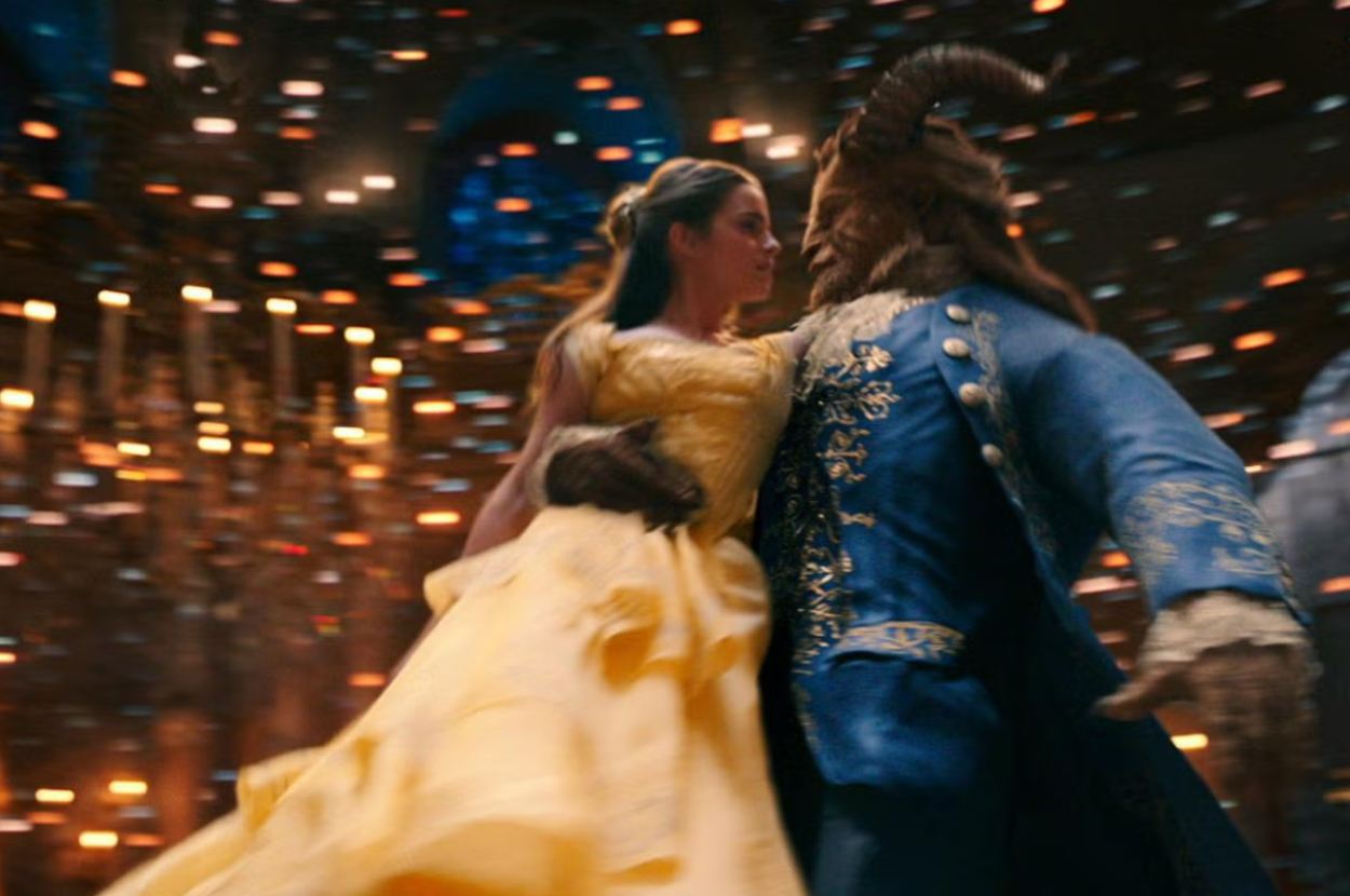 Belle in a yellow gown dancing with the Beast in a blue coat in Beauty and the Beast
