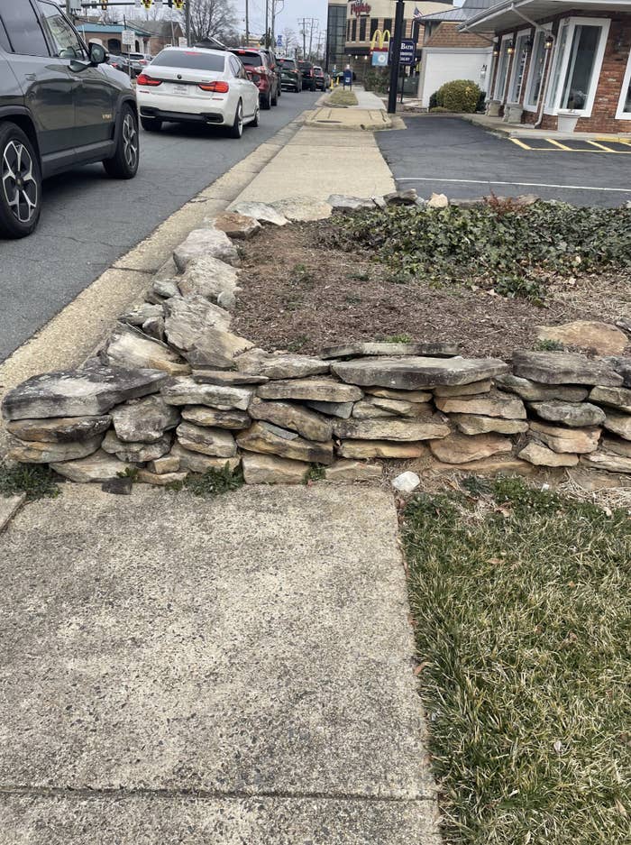 a stone garden in the middle of the sidewalk