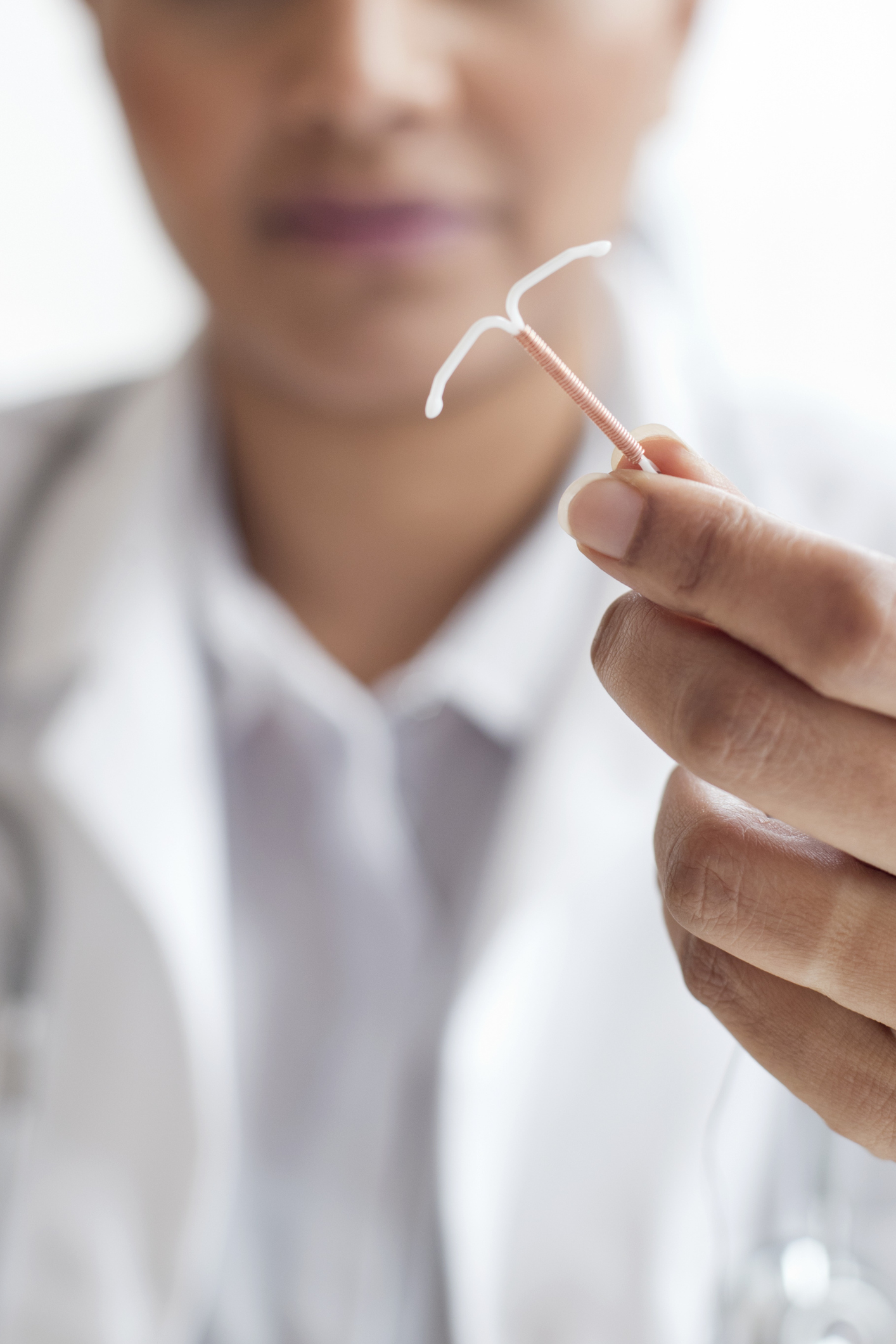 Healthcare professional holding an IUD contraceptive device