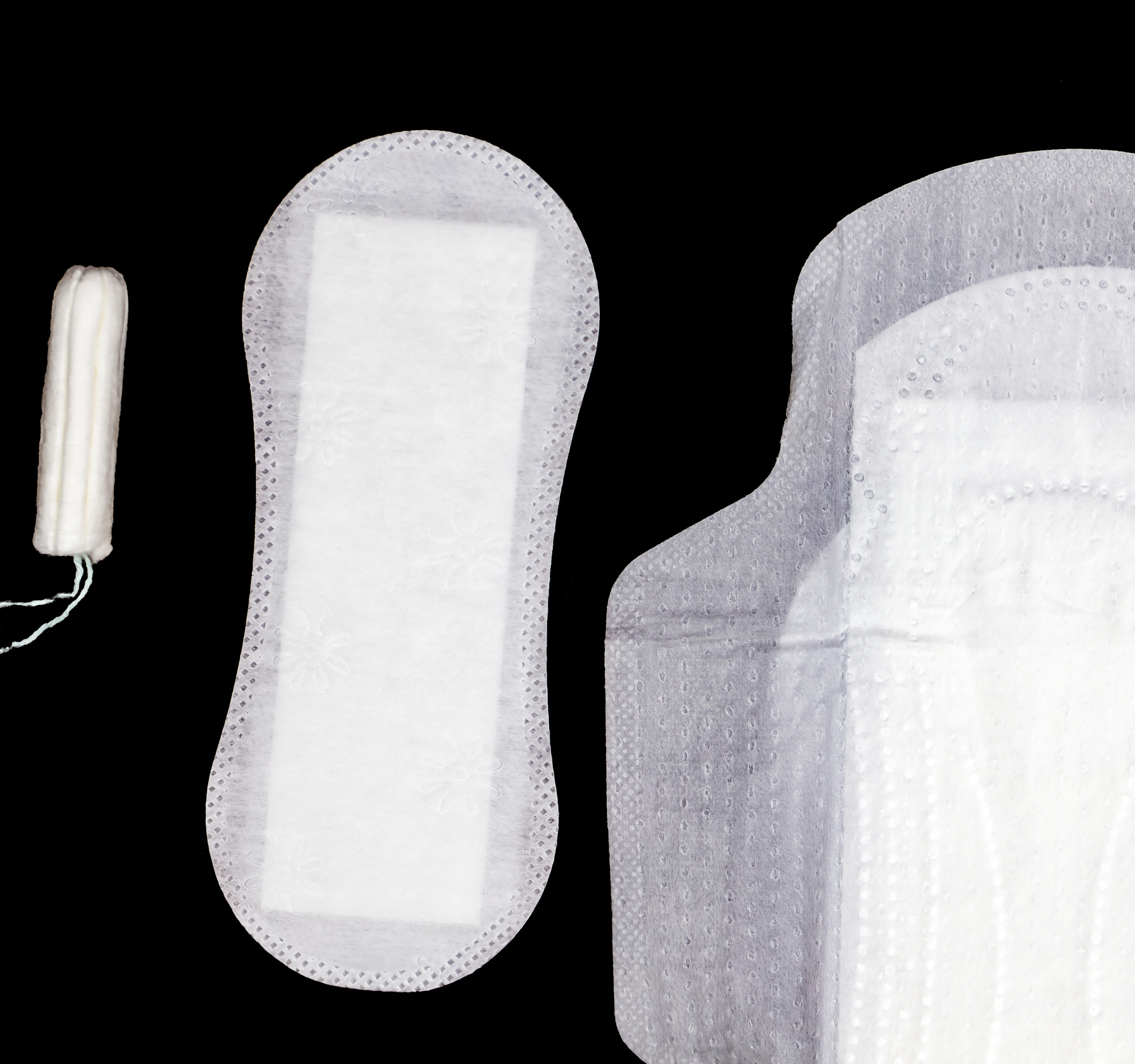 Feminine hygiene products including a tampon and sanitary pads on a dark background