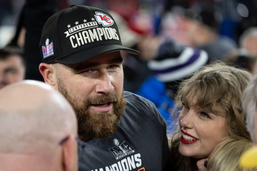 Travis Kelce in a &quot;Chiefs Champions&quot; hat with Taylor Swift, both smiling after the super bowl