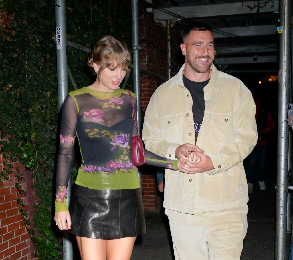 travis and taylor holding hands as they leave a building