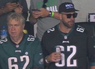 travis and his dad wearing Philadelphia Eagles jerseys seated at a game