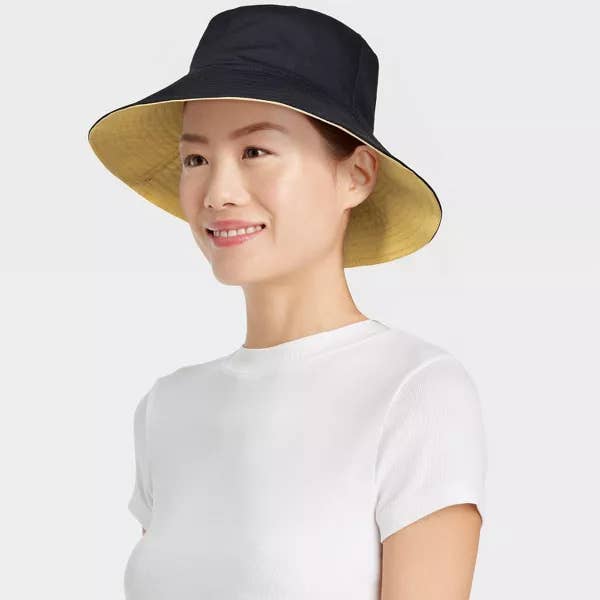 Model wearing the wide-brimmed hat in black and a plain white t-shirt