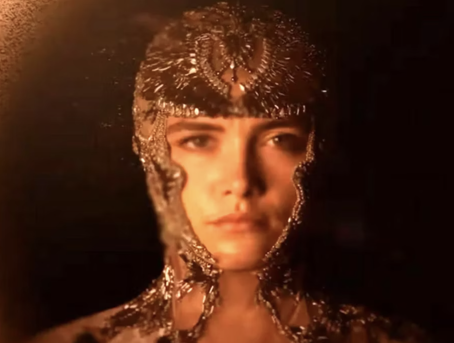 Persona con tocado y maquillaje de efectos especiales que simula líquido metálico sobre su cabeza y rostro